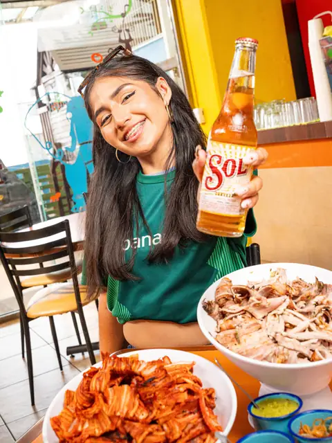 Clienta con una cerveza bien fría en la mano