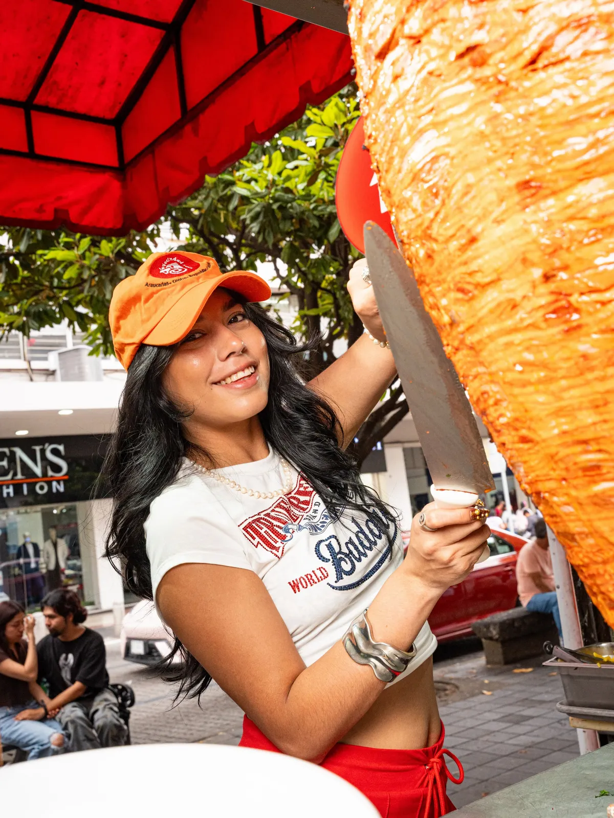 Taquera cortando el trompo al pastor en la sucursal