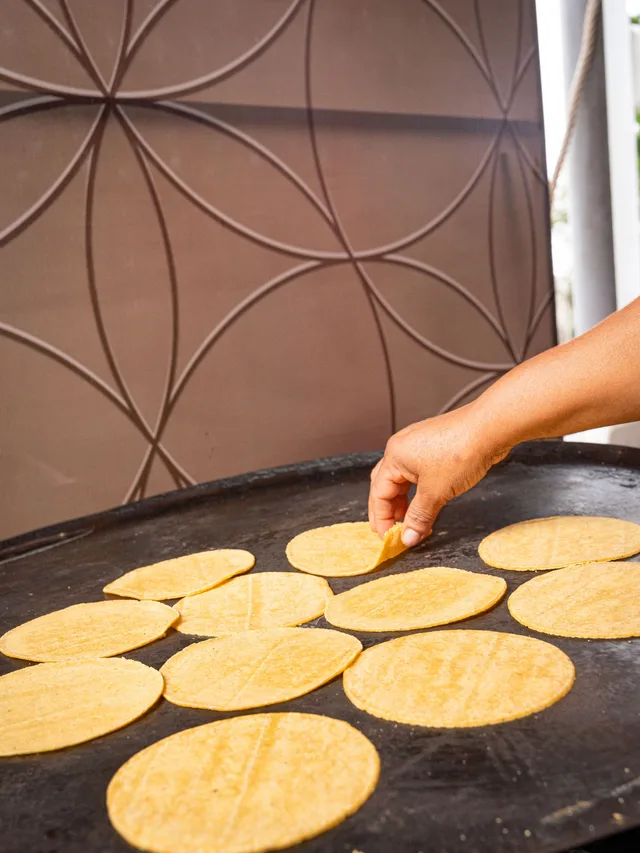 Tortillas de maíz calentándose en el comal de la taquiza